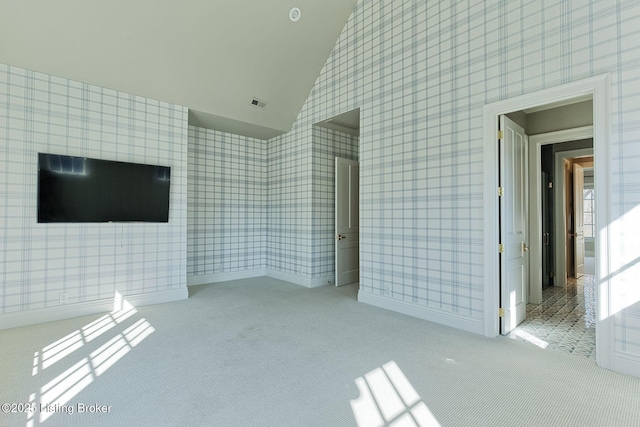 carpeted spare room with baseboards, high vaulted ceiling, visible vents, and wallpapered walls