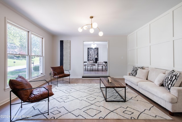 living room featuring crown molding, light wood-type flooring, and a notable chandelier