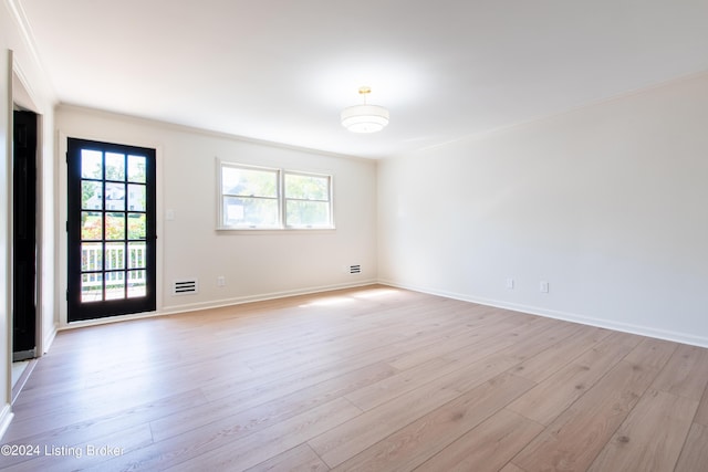 empty room featuring a healthy amount of sunlight, light wood-style flooring, and baseboards