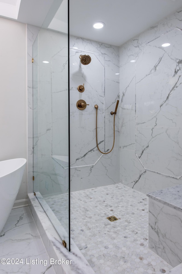 bathroom featuring marble finish floor, a marble finish shower, a freestanding bath, and recessed lighting