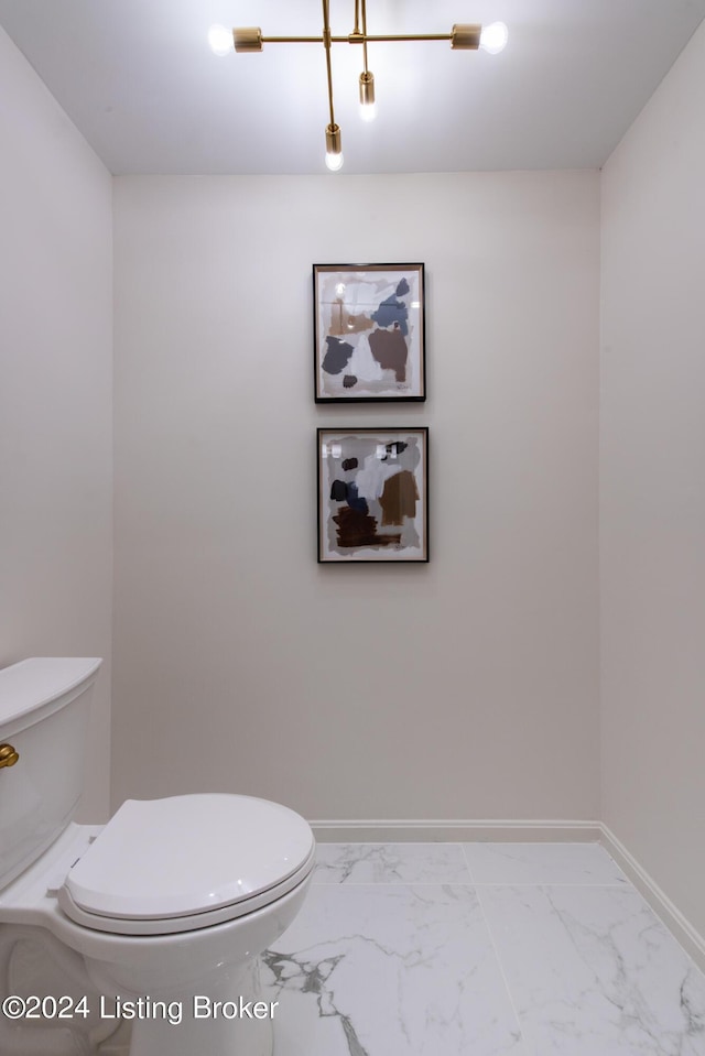 bathroom featuring marble finish floor, toilet, and baseboards