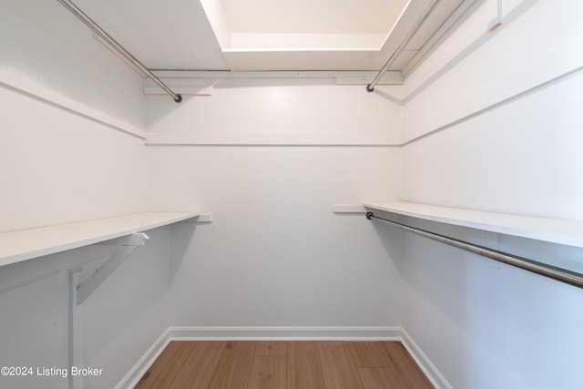 walk in closet with wood finished floors