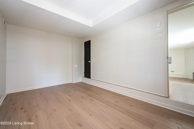 empty room featuring baseboards and light wood finished floors