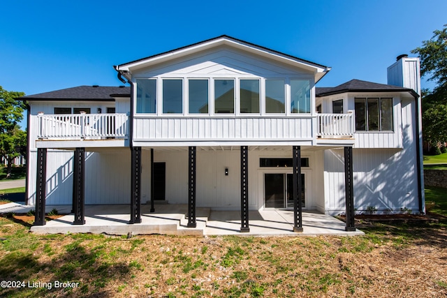 rear view of property featuring a patio and a lawn