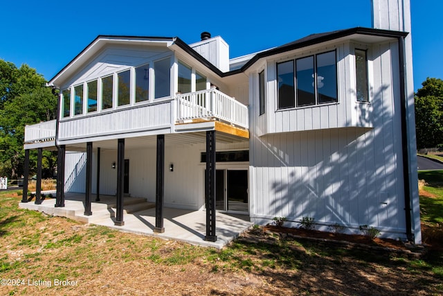 rear view of property featuring a patio area and a chimney