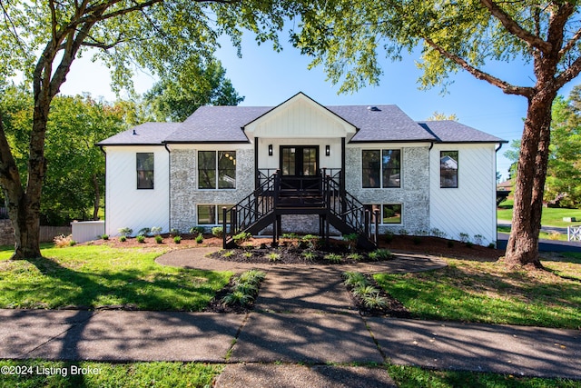 view of front facade featuring french doors, a shingled roof, fence, a front lawn, and stairs