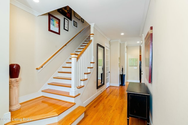 hallway with ornamental molding, recessed lighting, stairway, and wood finished floors