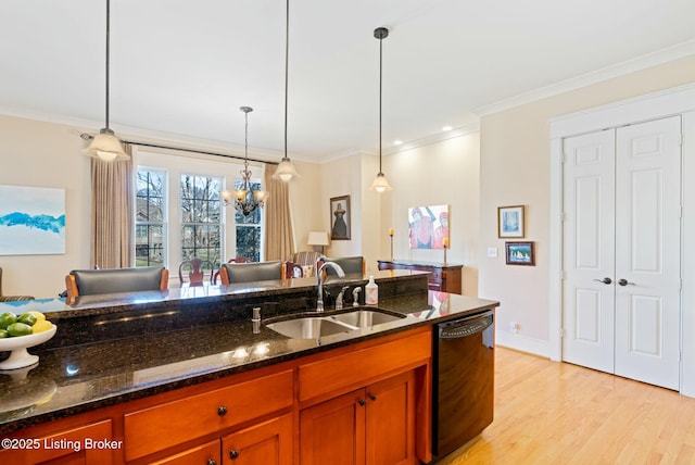 kitchen with a sink, dark stone countertops, pendant lighting, and dishwasher