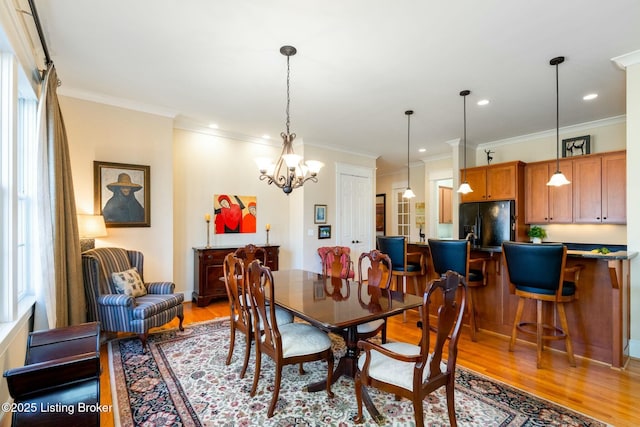 dining space featuring light wood-style flooring, ornamental molding, and recessed lighting