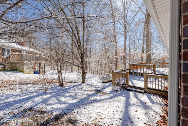 yard layered in snow featuring a wooden deck