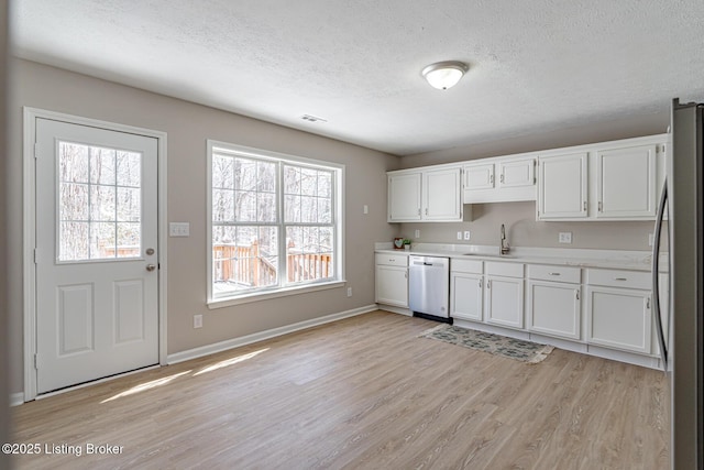 kitchen featuring a sink, white cabinetry, stainless steel appliances, and light countertops