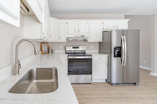 kitchen with under cabinet range hood, stainless steel appliances, a sink, white cabinetry, and light wood finished floors