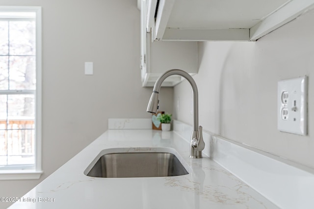 details with a sink and light stone countertops