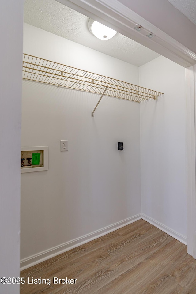 laundry room featuring hookup for a washing machine, a textured ceiling, and wood finished floors