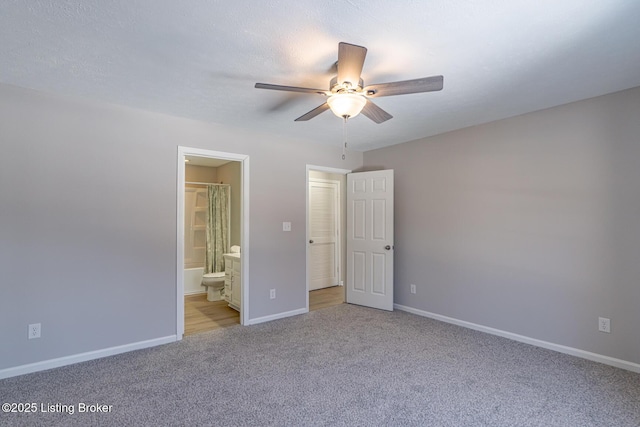 unfurnished bedroom featuring ceiling fan, baseboards, connected bathroom, and light colored carpet