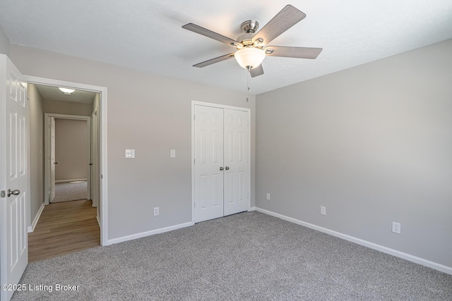 unfurnished bedroom featuring a ceiling fan, a closet, baseboards, and carpet flooring