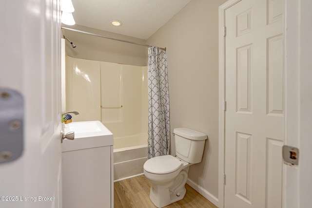 full bath with toilet, shower / bath combo with shower curtain, wood finished floors, and vanity