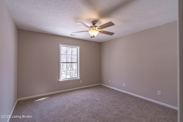 carpeted empty room with ceiling fan, a textured ceiling, visible vents, and baseboards