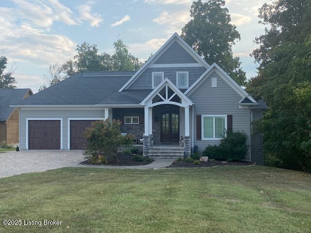 craftsman house featuring driveway, an attached garage, french doors, and a front lawn