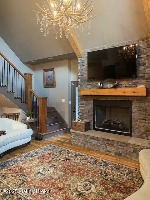 living room with a fireplace, stairway, and wood finished floors