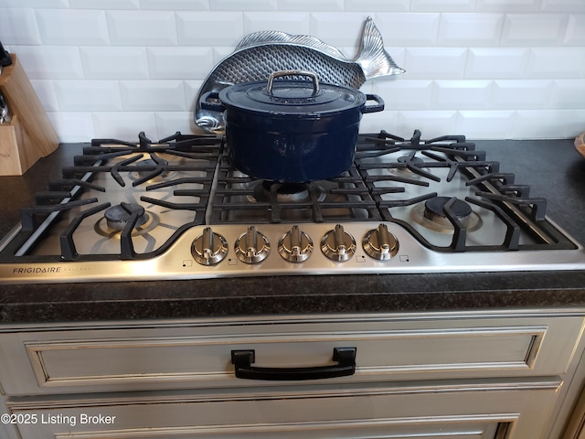 room details with gas stovetop, gray cabinets, dark stone counters, and decorative backsplash