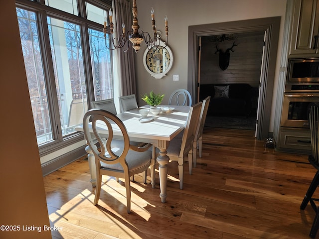 dining space with a notable chandelier and wood finished floors