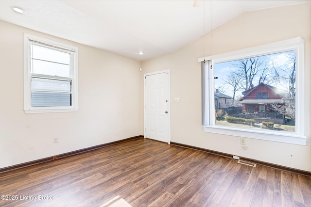 spare room with dark wood-style floors, lofted ceiling, recessed lighting, visible vents, and baseboards