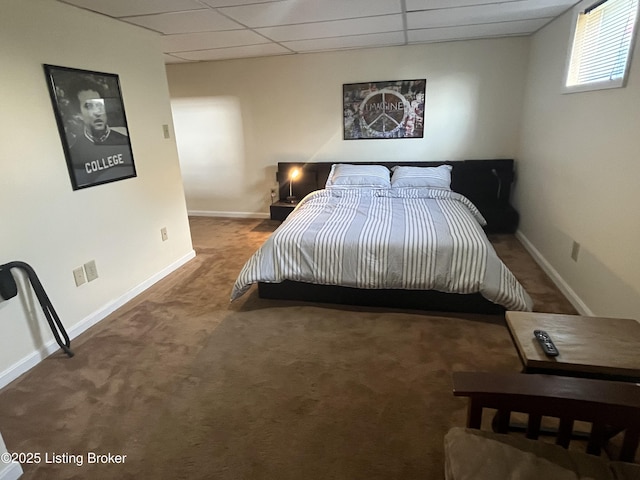 carpeted bedroom with a paneled ceiling and baseboards