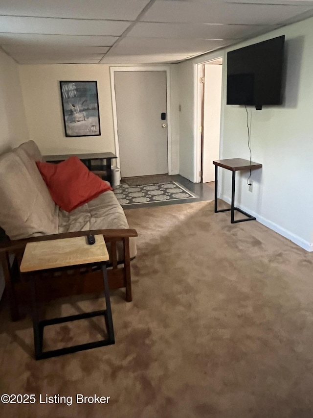 interior space with baseboards, a drop ceiling, and carpet flooring