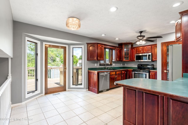 10207 El Coco Ct, Louisville, KY 40291 - kitchen with appliances with stainless steel finishes, dark brown cabinets, a ceiling fan, glass insert cabinets, and a peninsula