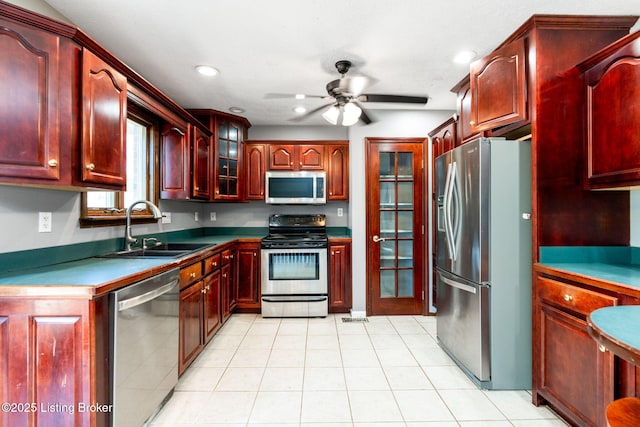 10207 El Coco Ct, Louisville, KY 40291 - kitchen with stainless steel appliances, reddish brown cabinets, ceiling fan, glass insert cabinets, and recessed lighting