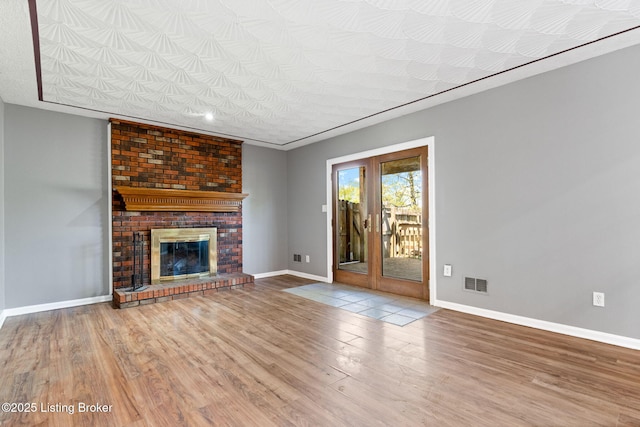 10207 El Coco Ct, Louisville, KY 40291 - unfurnished living room featuring wood finished floors, a brick fireplace, and french doors
