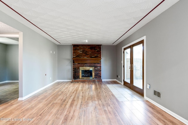 10207 El Coco Ct, Louisville, KY 40291 - unfurnished living room with light wood-style flooring and a brick fireplace