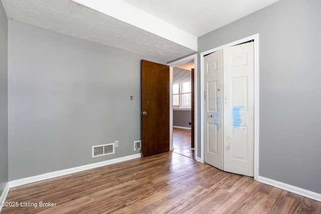 10207 El Coco Ct, Louisville, KY 40291 - unfurnished bedroom featuring wood finished floors, a closet, and a textured ceiling
