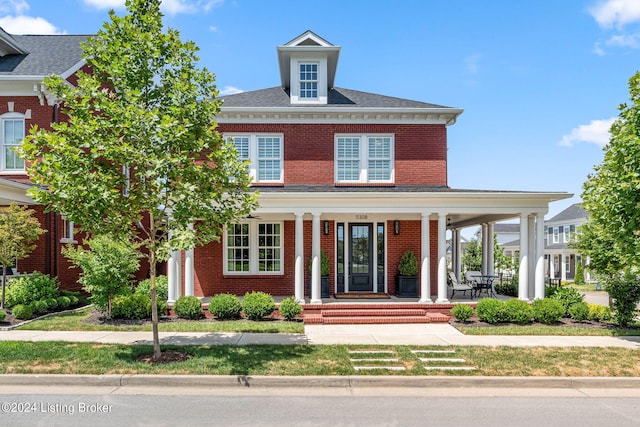 view of front of property featuring brick siding and a porch