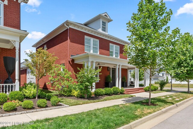 american foursquare style home with brick siding