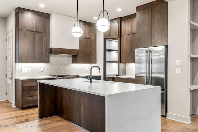 kitchen with pendant lighting, stainless steel appliances, a sink, and light countertops