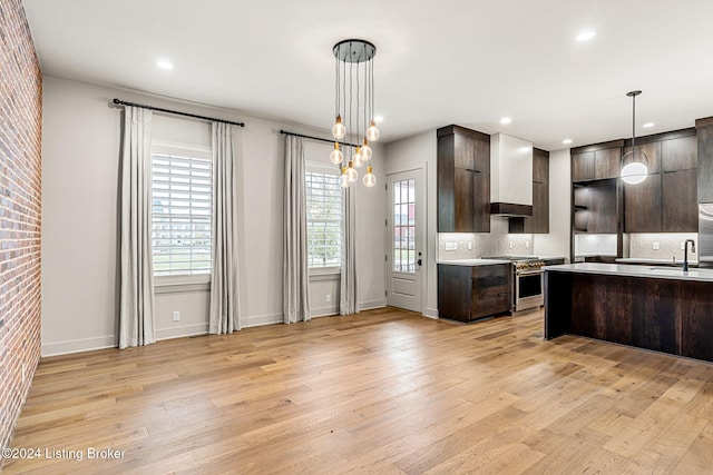 kitchen featuring light countertops, dark brown cabinets, modern cabinets, and high end stove