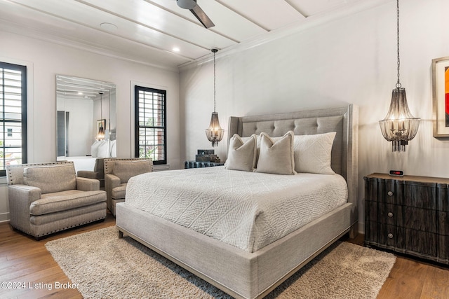 bedroom with recessed lighting, crown molding, and wood finished floors