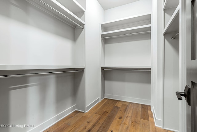 walk in closet with wood finished floors