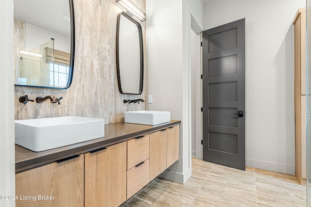 bathroom featuring double vanity, baseboards, backsplash, and a sink