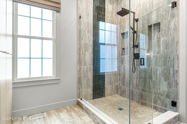 full bath featuring a stall shower, visible vents, and baseboards