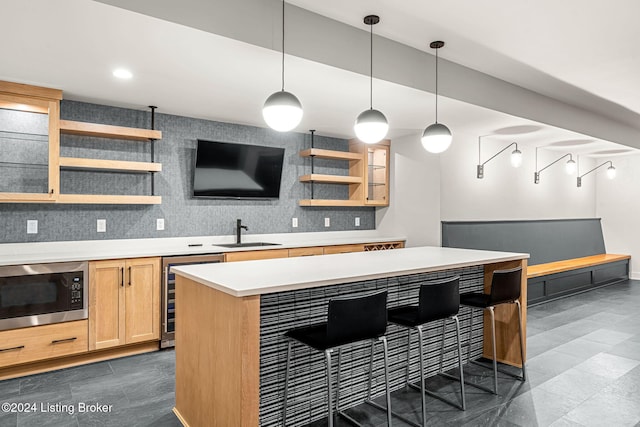 bar featuring tasteful backsplash, wine cooler, decorative light fixtures, black microwave, and a sink