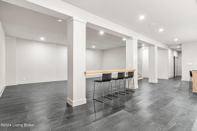 bar with baseboards, a bar, and recessed lighting