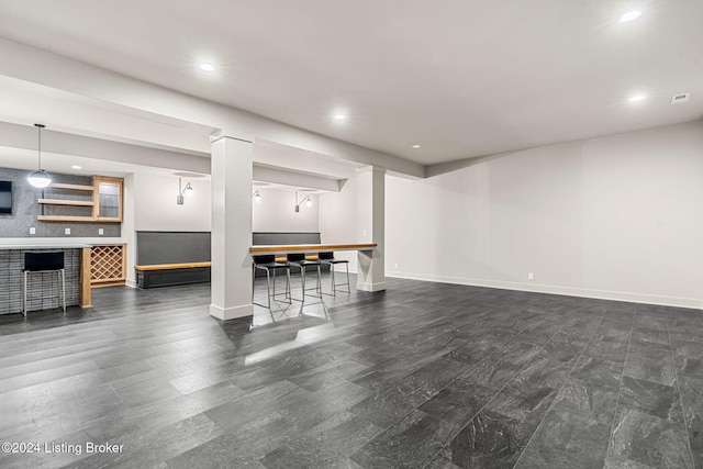 living room featuring a bar, baseboards, and recessed lighting