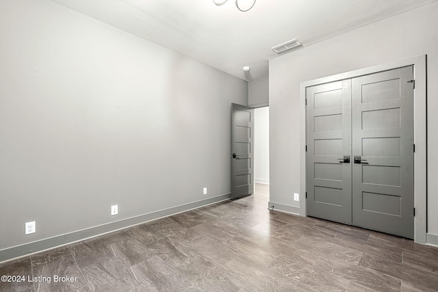 unfurnished bedroom with a closet, visible vents, and baseboards