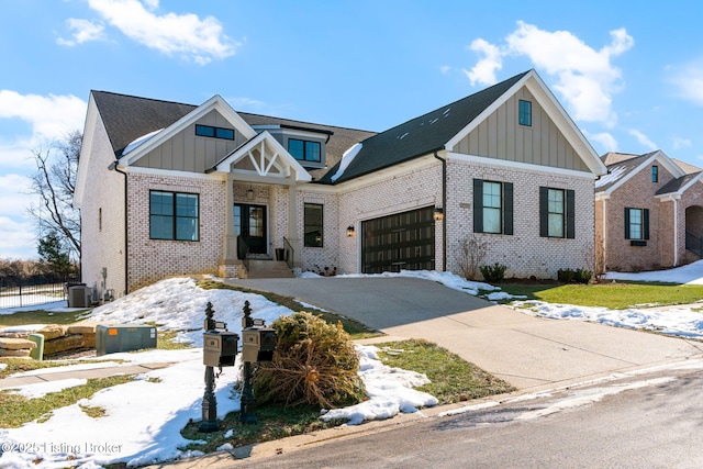 view of front of home featuring an attached garage, concrete driveway, board and batten siding, and brick siding