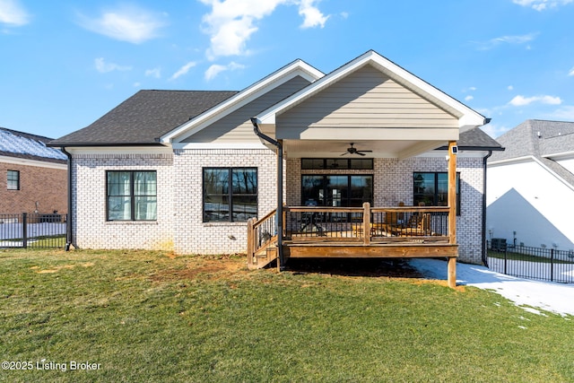 view of front of home featuring ceiling fan, a front lawn, fence, and brick siding