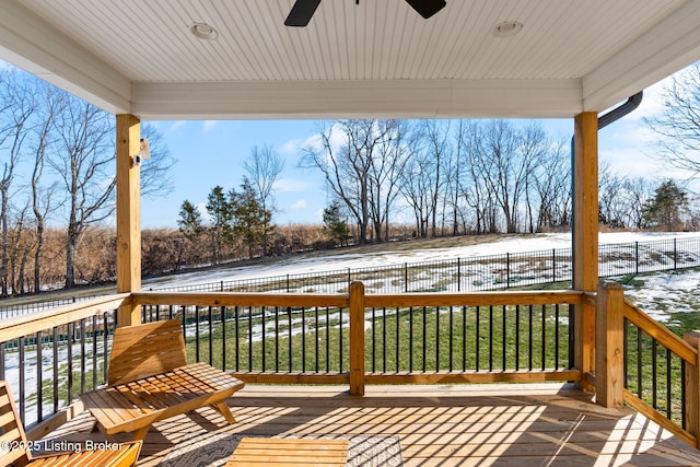 snow covered deck with a lawn, a fenced backyard, and a ceiling fan