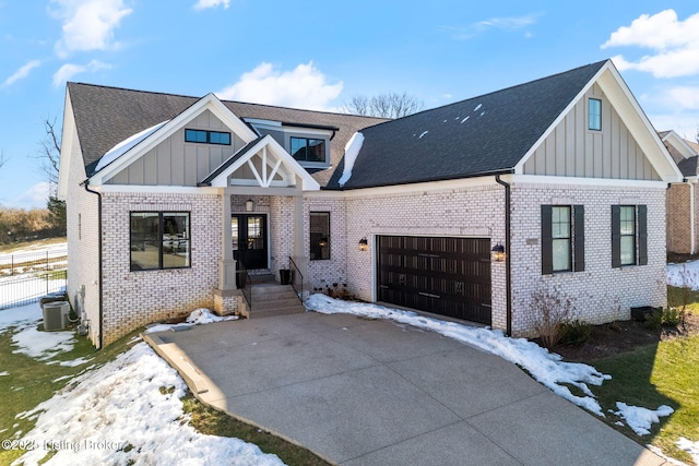 view of front of house with central AC, concrete driveway, board and batten siding, and an attached garage